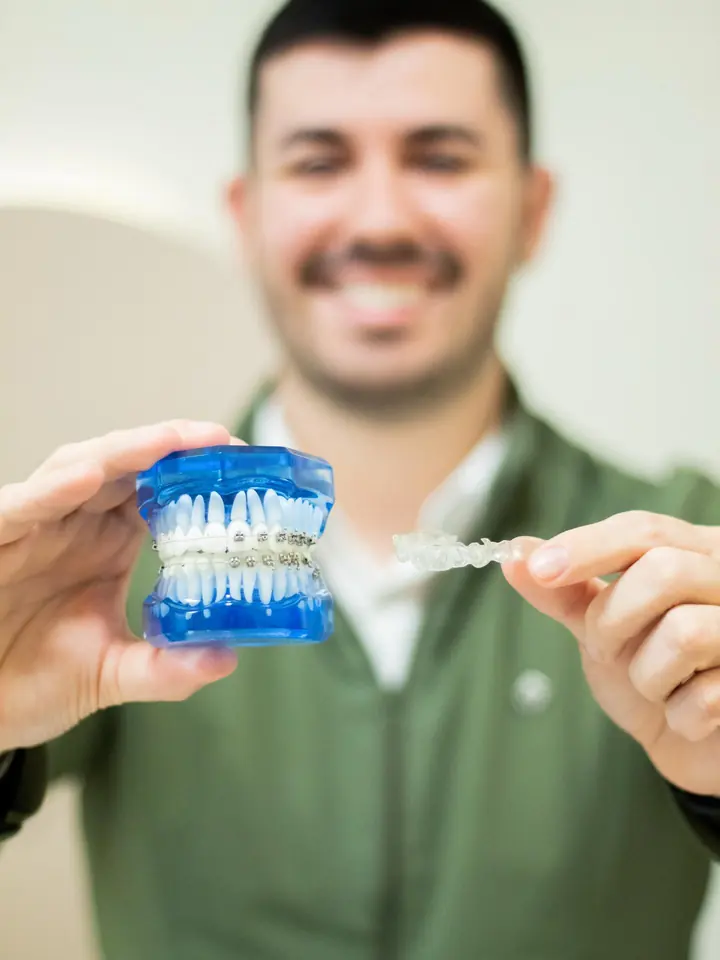 Dentista mostrando o aparelho fixo e o alinhador transparente
